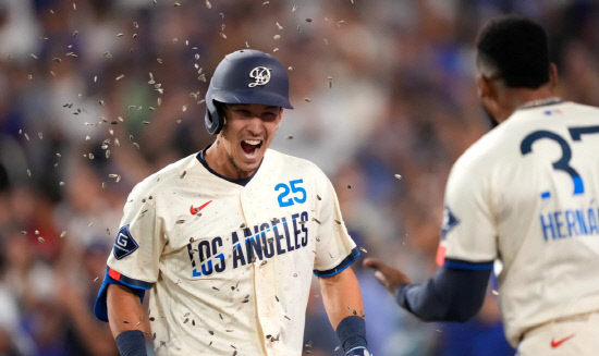 LA다저스 토미 에드먼이 3-2로 뒤지던 7회말 2사 1,2루에서 역전 3점홈런을 날리고 덕아웃으로 돌아오다가 테오스카 에르난데스가 뿌리는 해바라기씨 세리머니에 즐거워하고 있다.[AP=연합]