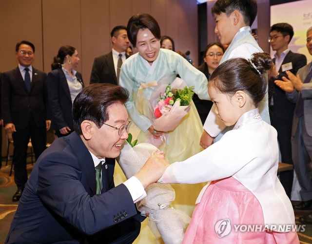 이재명 대통령과 김혜경 여사가 28일(현지시간) 브라질 상파울루 한 호텔에서 열린 동포 오찬간담회에서 화동과 인사하고 있다. (상파울루=연합)